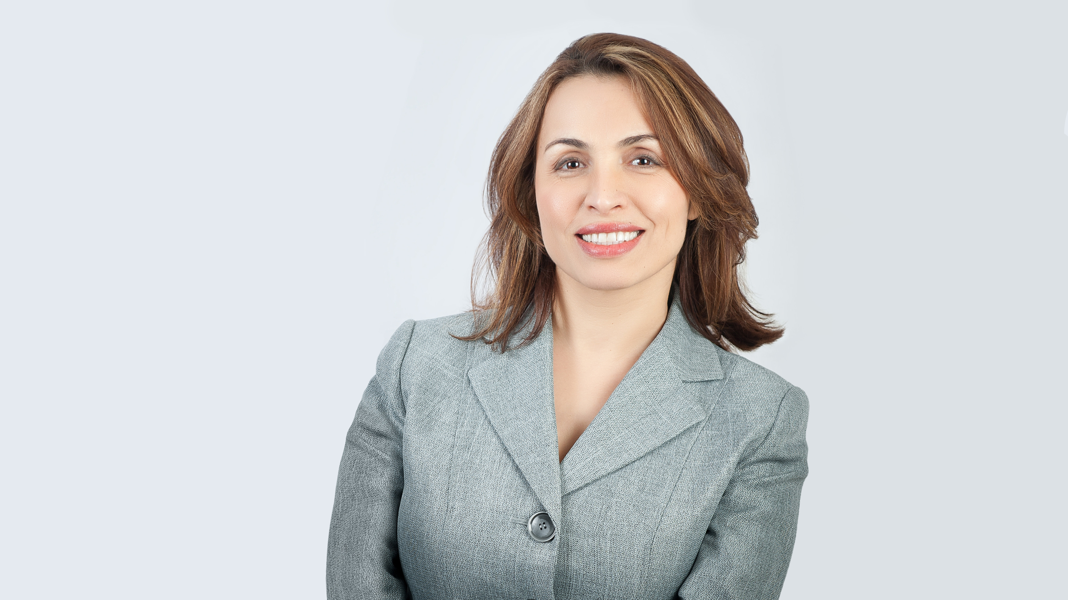 A smiling woman against a neutral background